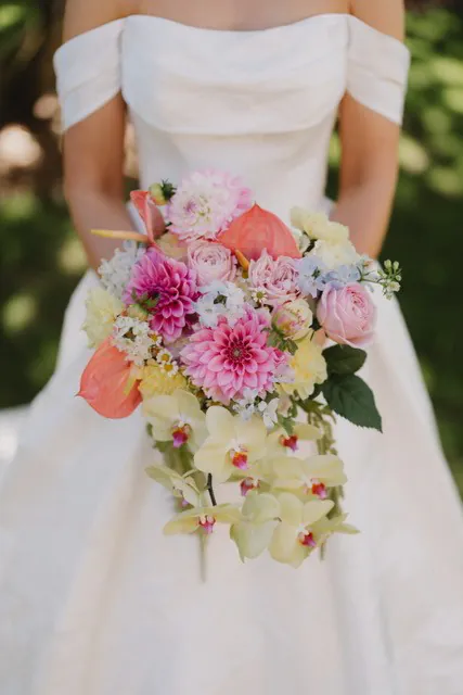 Close view of Delaney's bouquet with pink and white flowers, pale yellow orchids and greenery.